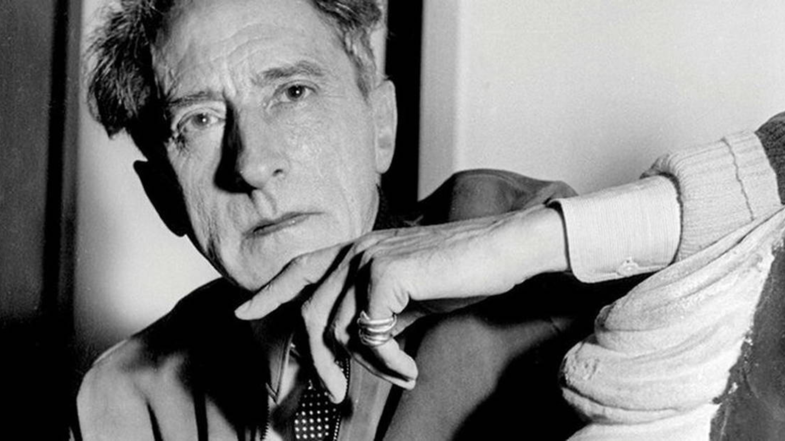 Jean Cocteau portant deux bagues Trinity de Cartier sur son petit doigt, symbolisant son rôle dans l’élévation de ce bijou au rang d’icône intemporelle.