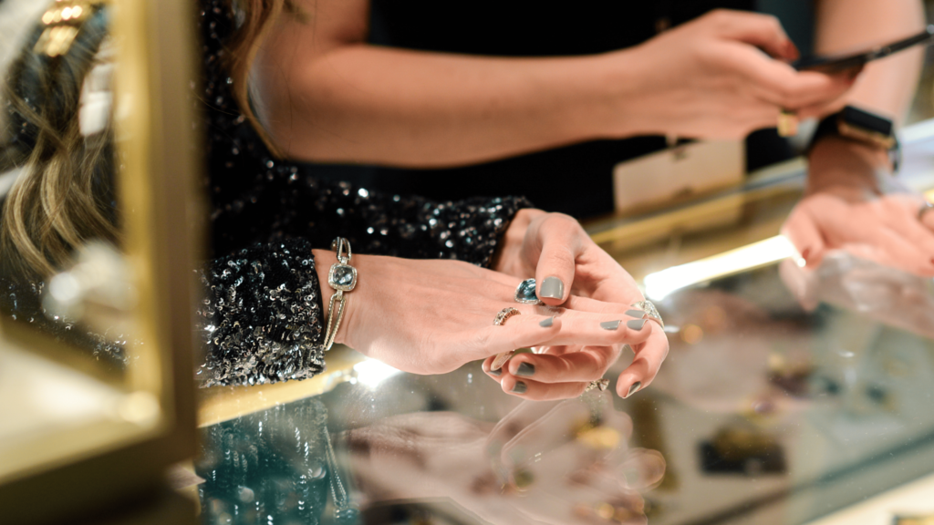 A visitor trying on luxurious jewelry at The Winter Show, showcasing exceptional craftsmanship and rare pieces at New York’s prestigious art and design fair.