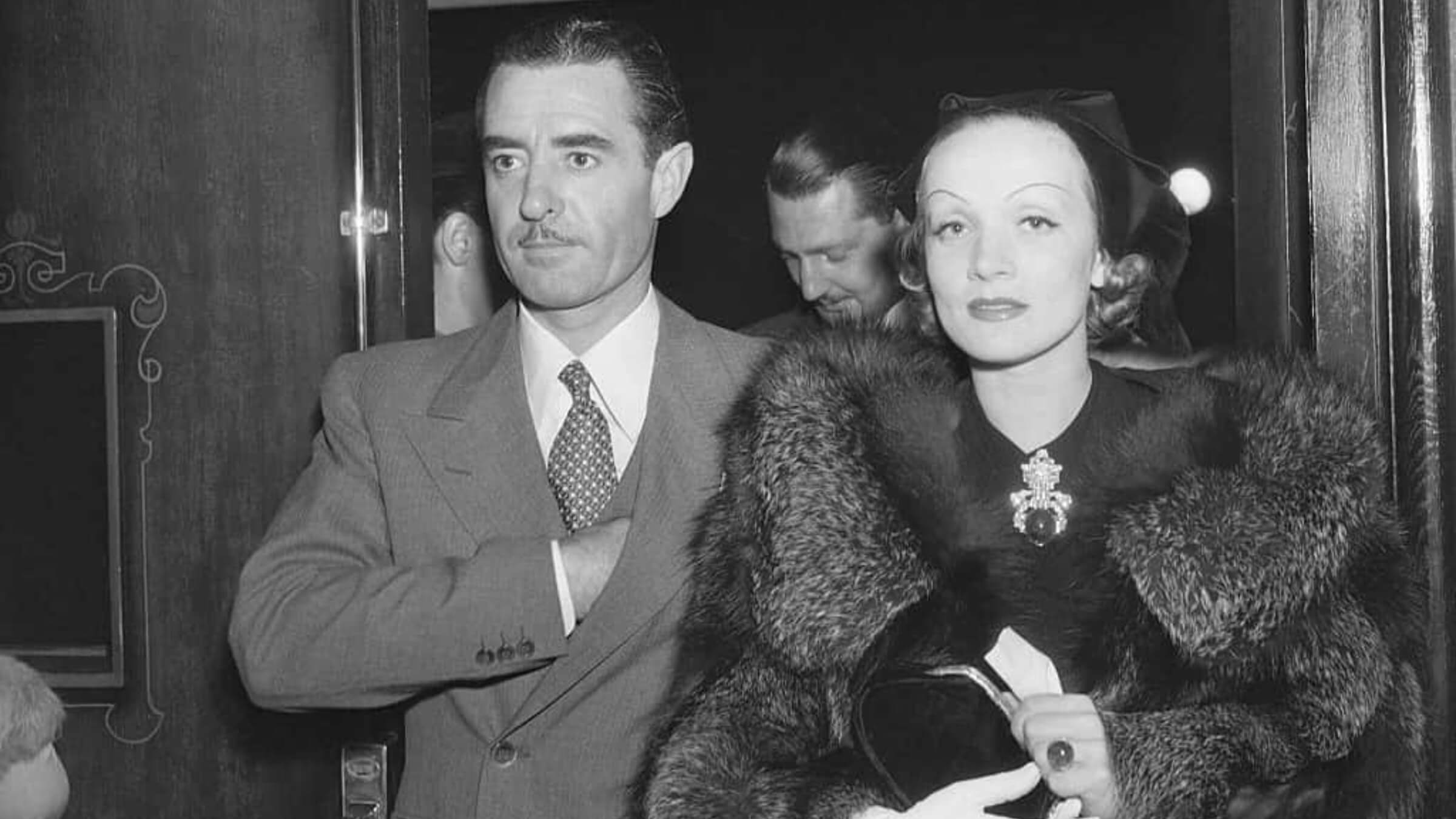 Marlène Dietrich wearing an emerald and diamond brooch by Trabert & Hoeffer-Mauboussin a ring by Paul Flato